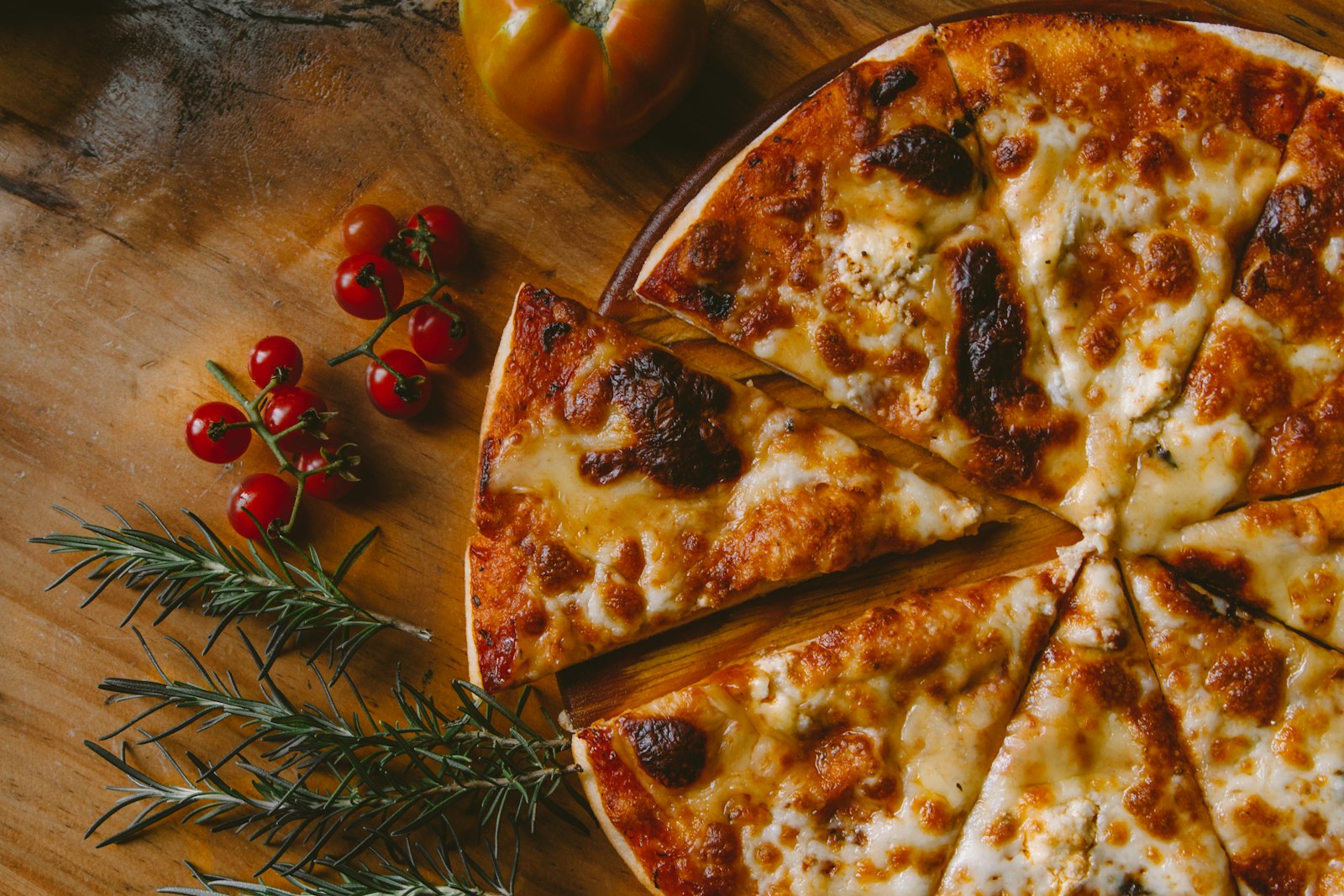 Pizza de queso dorada sobre tabla de madera